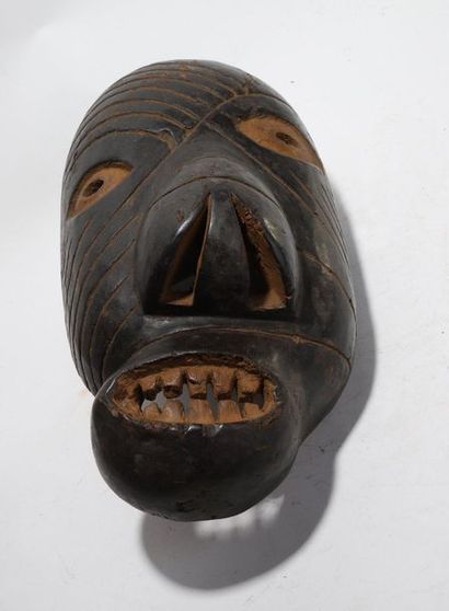 Decorative mask with a deformed face 

Incised...
