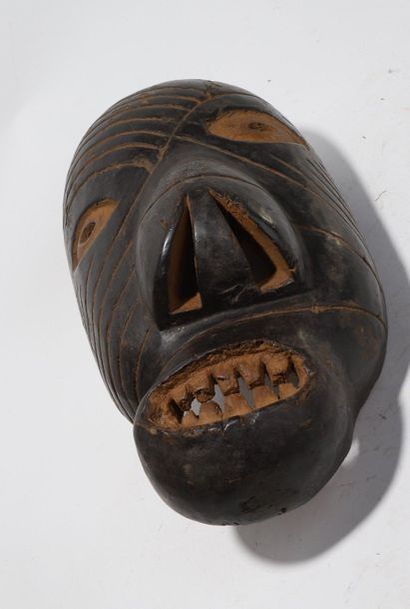 Decorative mask with a deformed face 

Incised...