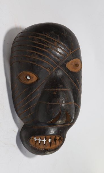 Decorative mask with a deformed face 

Incised...
