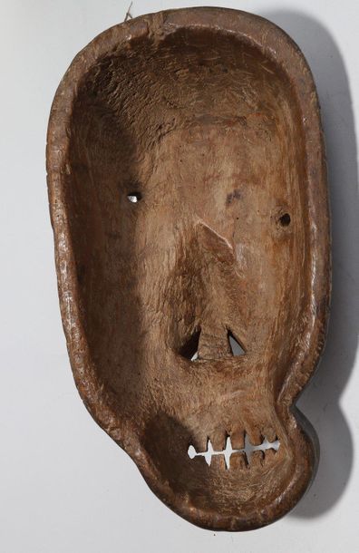 Decorative mask with a deformed face 

Incised...