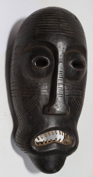 Decorative mask with a deformed face 

Wood...