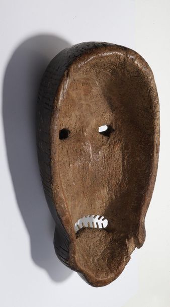 Decorative mask with a deformed face 

Wood...