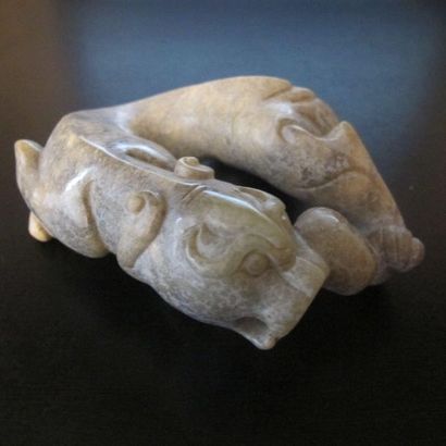 Jade tiger turning around. Patinated celadon...