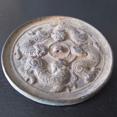 Mirror with four tigers biting the disc of...