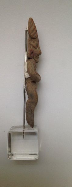 Female figurine standing with crossed arms...