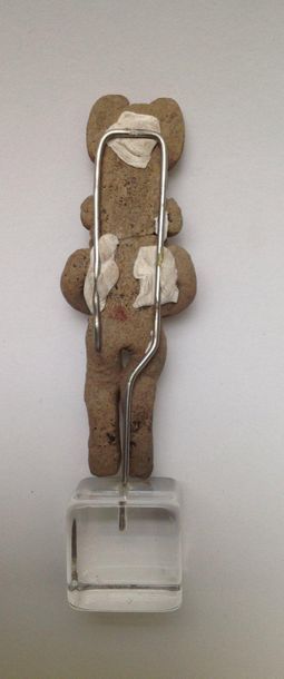 Female figurine standing with crossed arms...