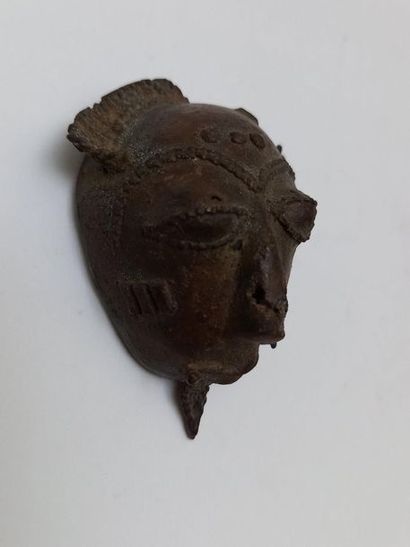 Old brass talisman mask with a patina of...