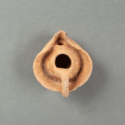 A Punic oil lamp in pink clay with a collar...