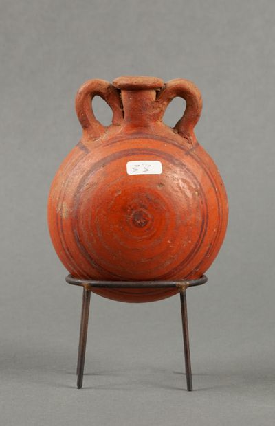 Orange terracotta flask decorated with brown...