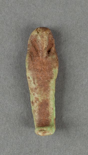 Oushebti miniature en fritte émaillée verte.

Egypte,...