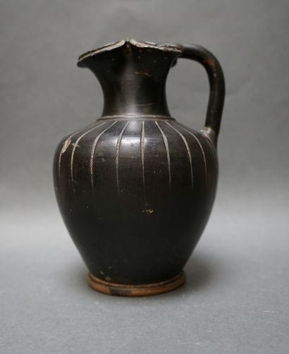 A black ceramic oenochoe with a trefoil spout...
