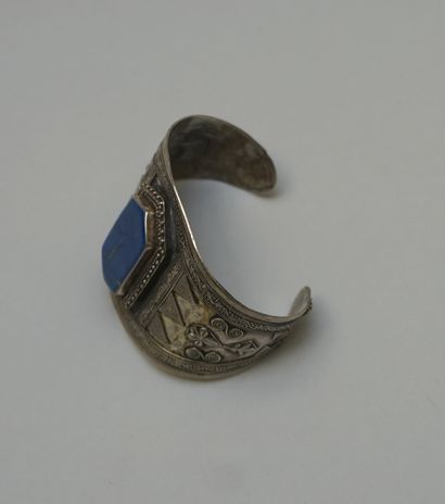 A large rigid silver BRACELET centered on...
