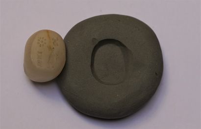 White marble seal showing a standing priest....
