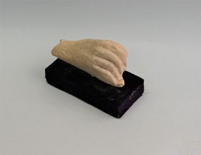 Hand holding a disc finely executed in limestone.

Hellenistic...