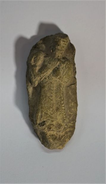 Grey stone fragment showing a figure holding...