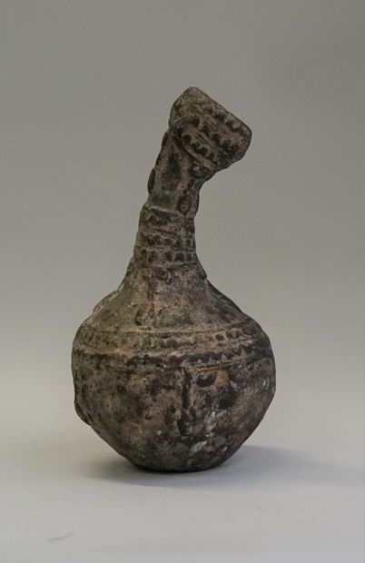 Bronze libation vase with curved neck, decorated...