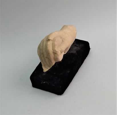 Hand holding a disc finely executed in limestone.

Hellenistic...