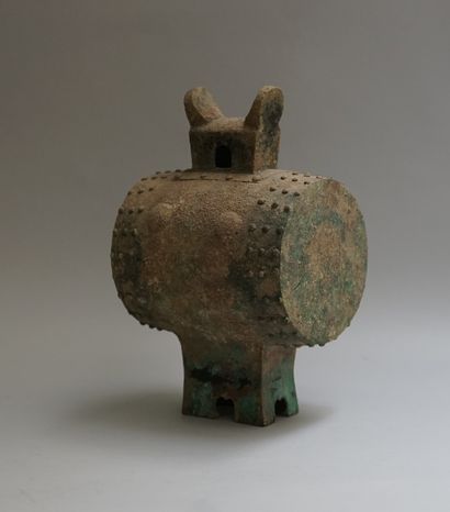 Copper drum resting on a quadripod base and...