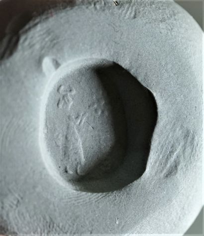 White marble seal showing a standing priest....