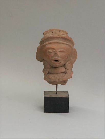 Head in pinkish terracotta represented with...