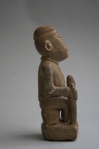 Figure showing a seated chief holding a stick....