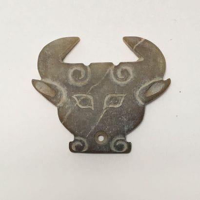 Very stylized brown/yellow jade bovine head....