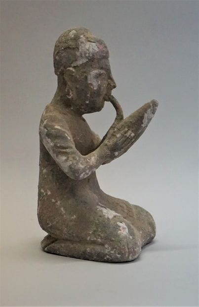 Kneeling figure smoking a pipe. Stuccoed...