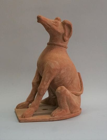 Statue of a sitting greyhound. Orange terracotta....