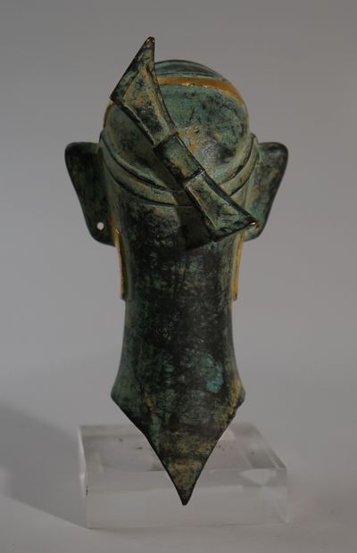 Head in bronze with green and gold patina....