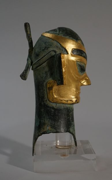 Head in bronze with green and gold patina....
