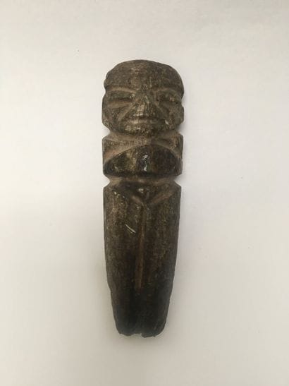 Monolithic figure standing in dark green...