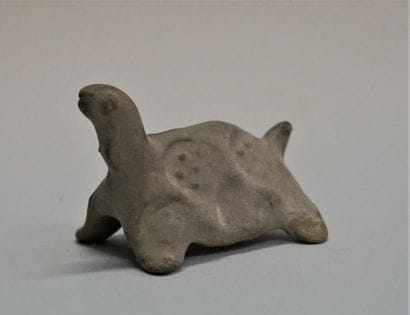 Small turtle in orange clay. One front leg...