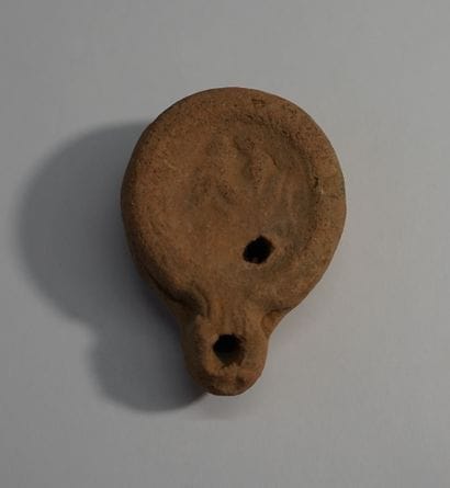 Red terracotta oil lamp with erotic decoration....