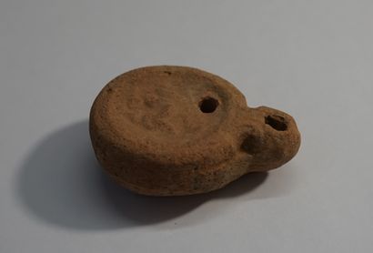 Red terracotta oil lamp with erotic decoration....