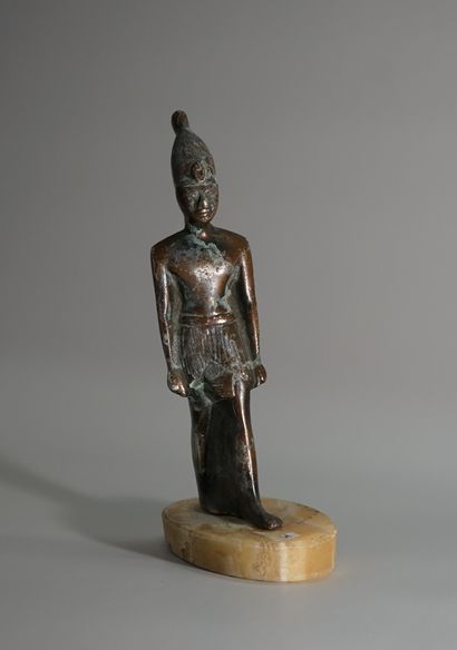 Egyptian statuette of a deity in regula with...