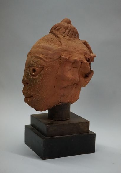 Tête présentant un visage aux yeux triangulaires...