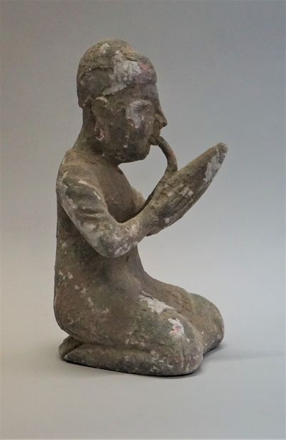 Kneeling figure smoking a pipe. Stuccoed...