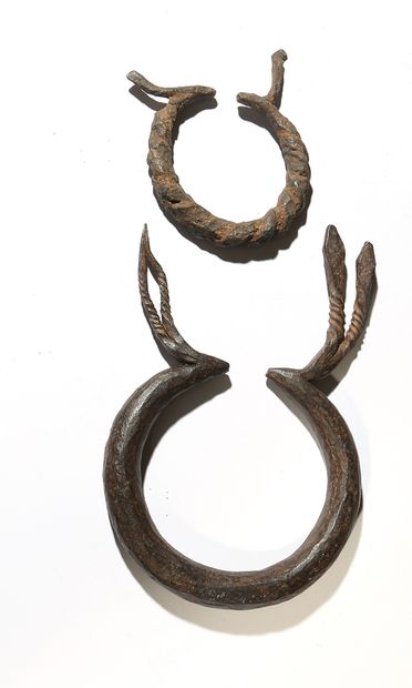 Two coins in the shape of torques. One with...