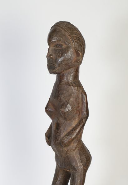 Statue féminine présentée debout, les jambes...