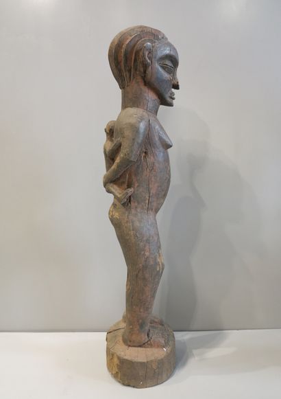 Statue anthropomorphe féminine debout tenant...