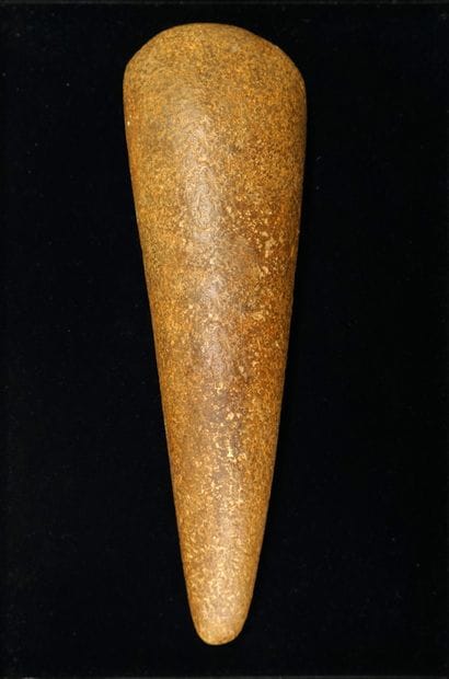 Important polished axe made of caramel beige...