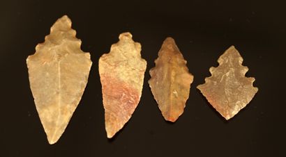 Four Neolithic denticulated flint arrowheads....