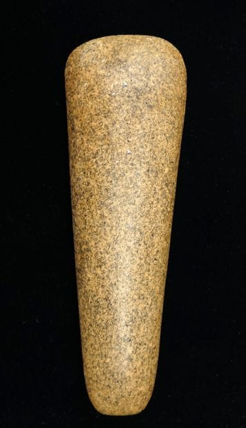 Polished axe in beige speckled stone. Possibly...