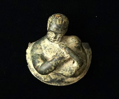 Medallion representing a chubby child holding...