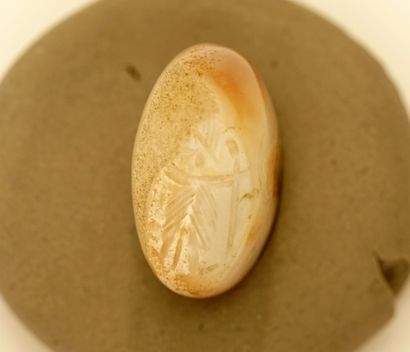 Seal in white and beige agate showing a priest...