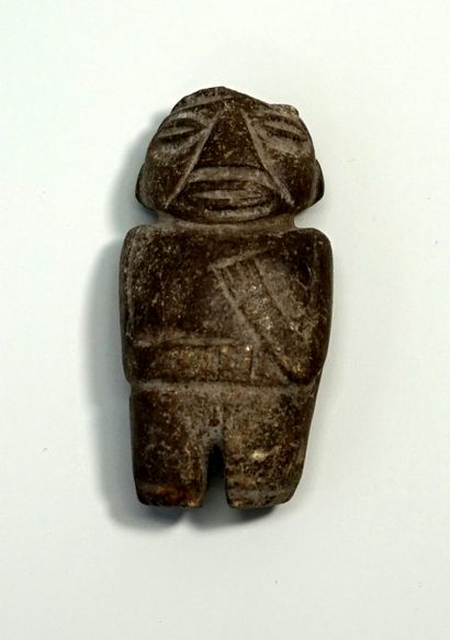 Petite idole anthropomorphe en pierre brune....