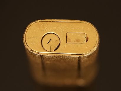 CARTIER - BRIQUET en plaqué or à décor guilloché....