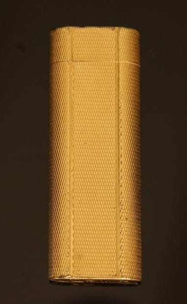 CARTIER - BRIQUET en plaqué or à décor guilloché....