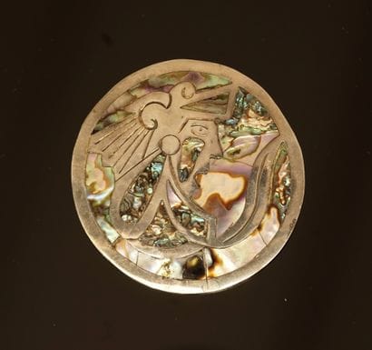 Round 925/°° silver brooch presenting a South...