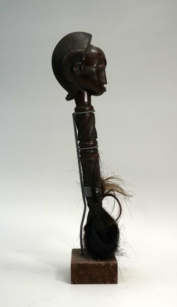 Chasse mouche terminé par une tête coiffée...